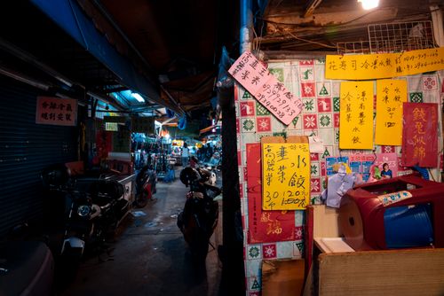 Free A lively Asian bazaar at night featuring colorful signs and scooters, creating an authentic local vibe. Stock Photo