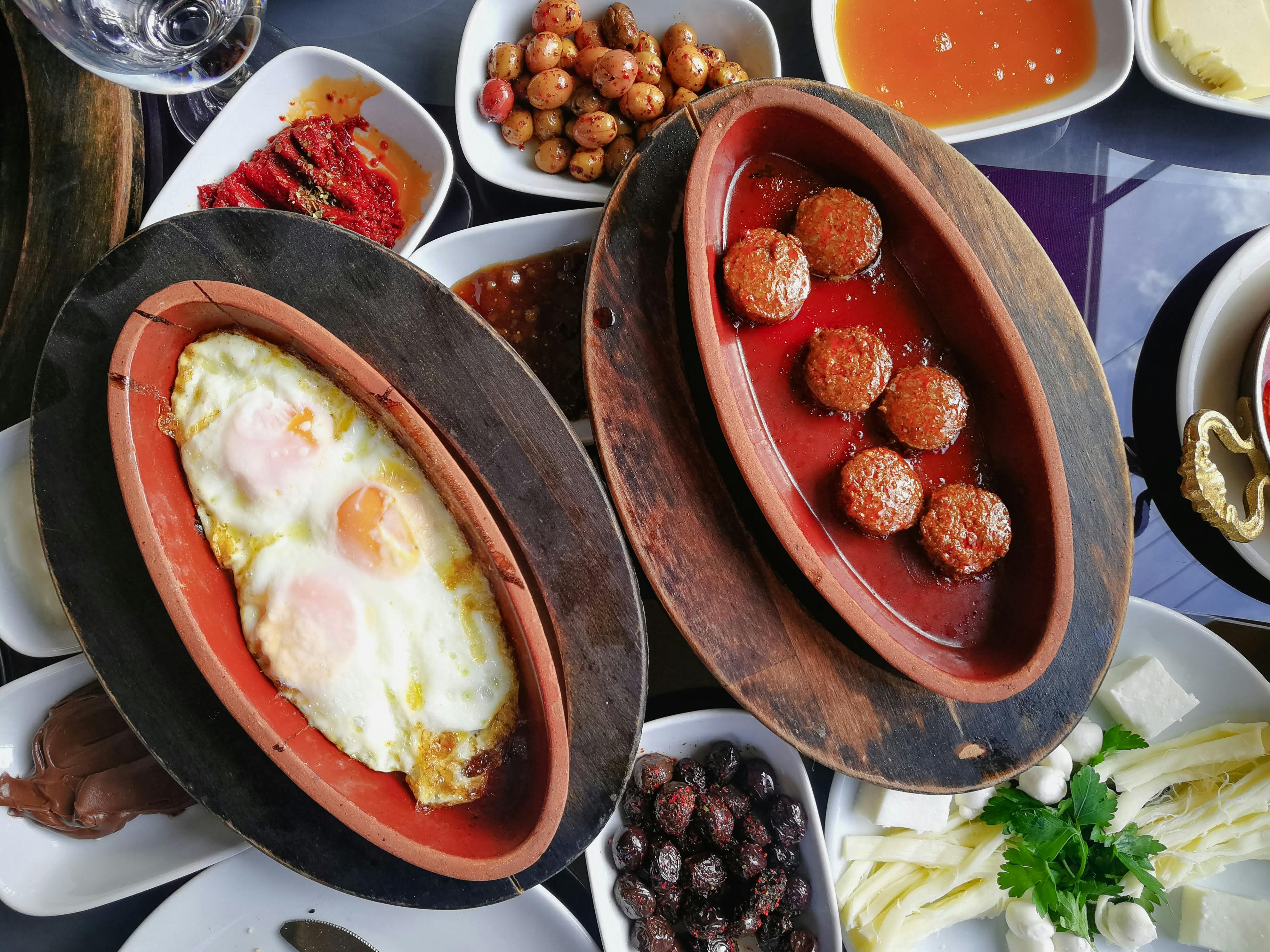 Top view of a traditional Turkish breakfast featuring eggs, meatballs, and assorted meze dishes. - Photo by Mehmet Turgut  Kirkgoz on Pexels