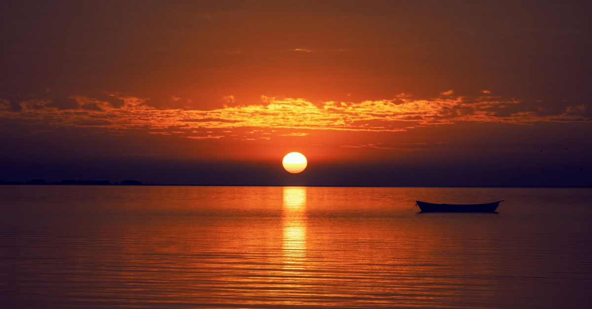 sunrise over a calm ocean horizon, symbolizing endurance and hope