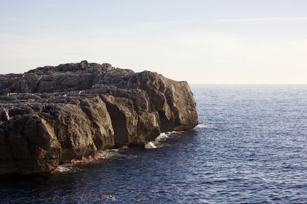 Eroded coastal cliffs above a calm sea — photo by Ben Roussel on Pexels