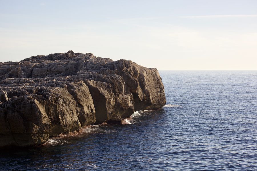Rocky coastline with eroded cliffs and calm sea — photo by Ben Roussel on Pexels