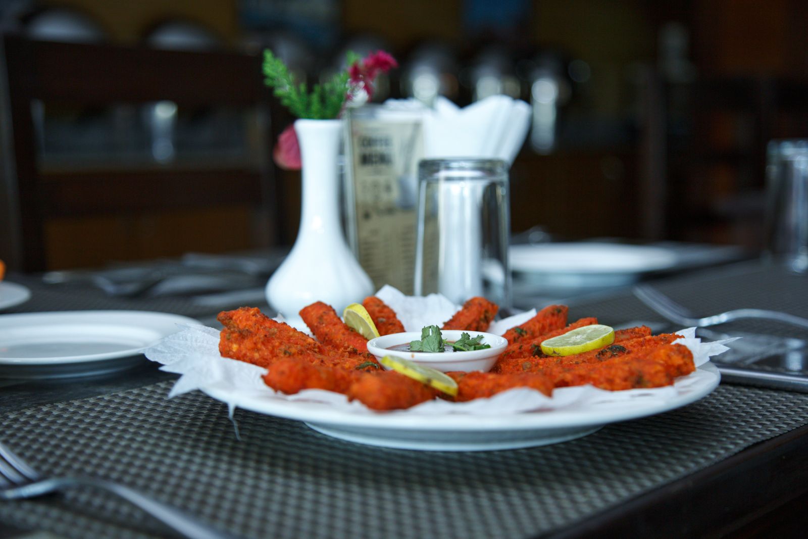 Close-up of a spicy appetizer with lemon garnish served in a restaurant in Pokhara, Nepal.