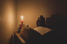 Candlelit desk with an open book — photo by Arturo Añez on Pexels