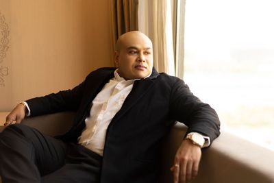 Confident businessman sitting indoors, gazing outside with a thoughtful expression
