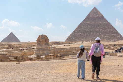 Mother Walking with Daughter towards Pyramids