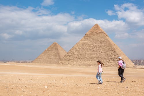 Mother Walking with Daughter near Pyramids
