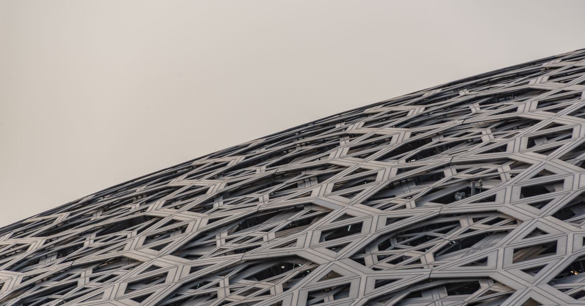Close-up of the intricate geometric dome roof of Louvre Abu Dhabi, showcasing modern architecture.