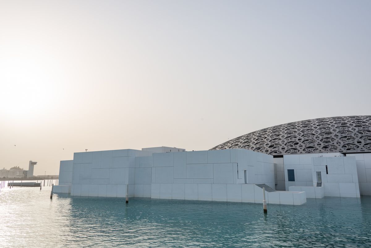 Geometric dome of Louvre Abu Dhabi casting light patterns on Saadiyat Island waterfront