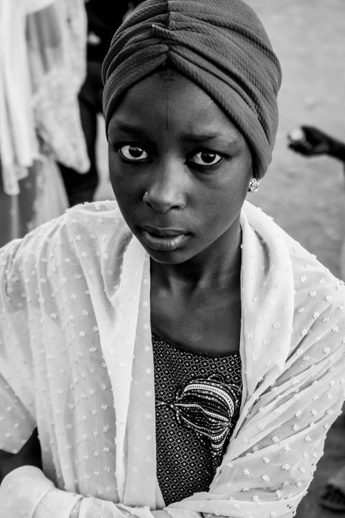 Free Striking black and white portrait of a woman in traditional attire, looking up with a solemn expression. Stock Photo