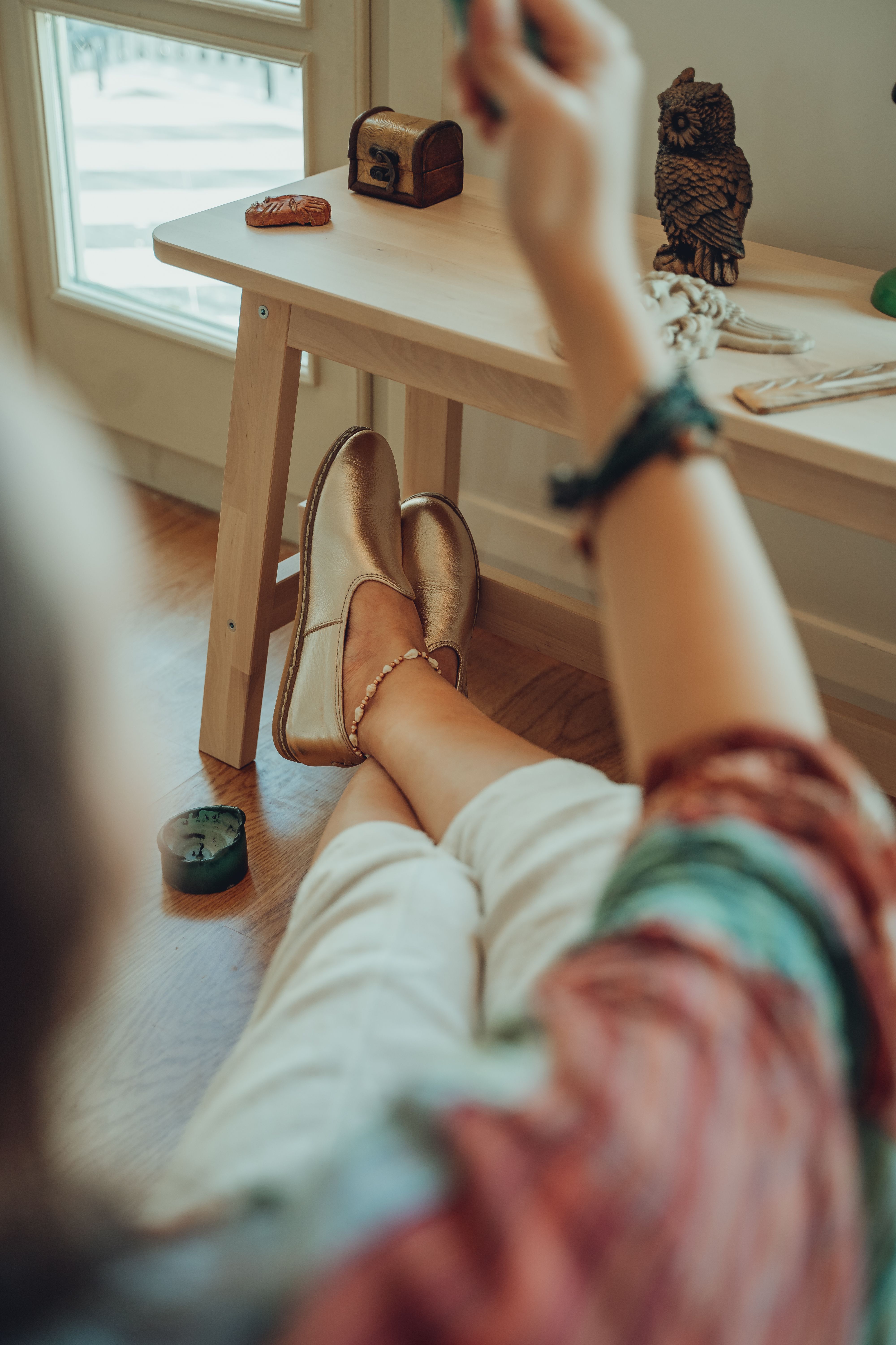 Cozy indoor scene of woman relaxing with stylish shoes and decor.