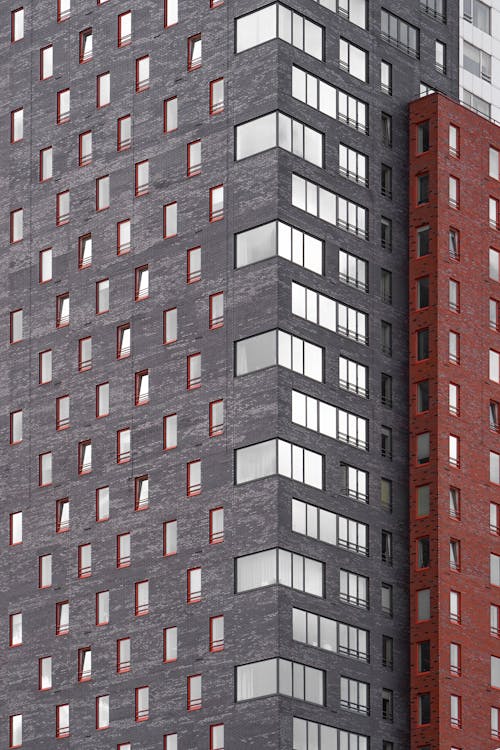 Facade of gray brick wall with windows. Abstract architecture