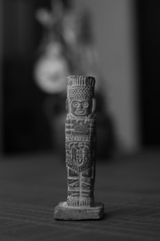 Black and white photo of an intricately carved totem sculpture, highlighting its details.