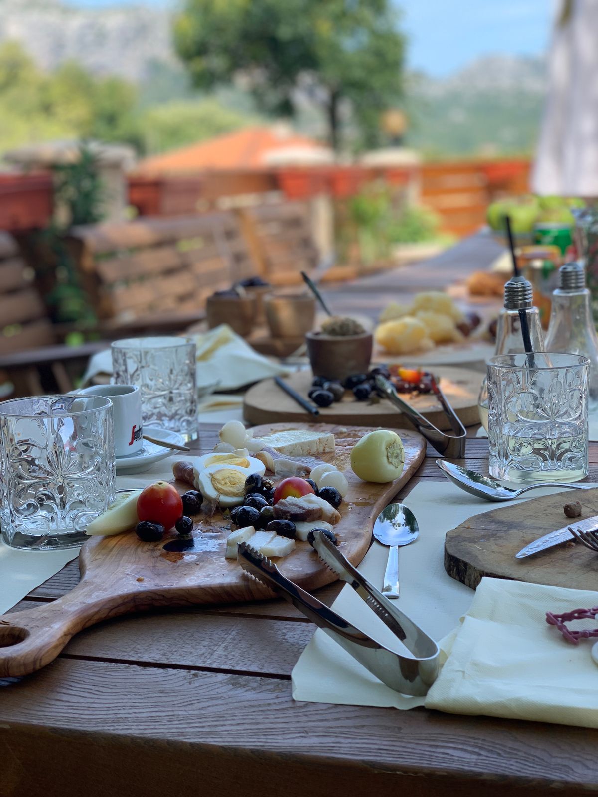 A rustic mountain terrace spread of cheese, ham and wine