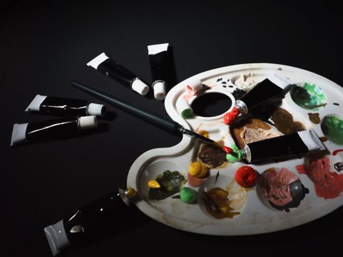 Free Artist's palette with paint tubes and brushes in a creative workshop setting. Stock Photo