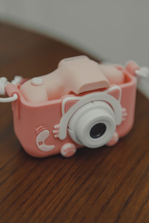 Free Adorable pink toy camera with a whimsical and playful design, perfect for children. Stock Photo