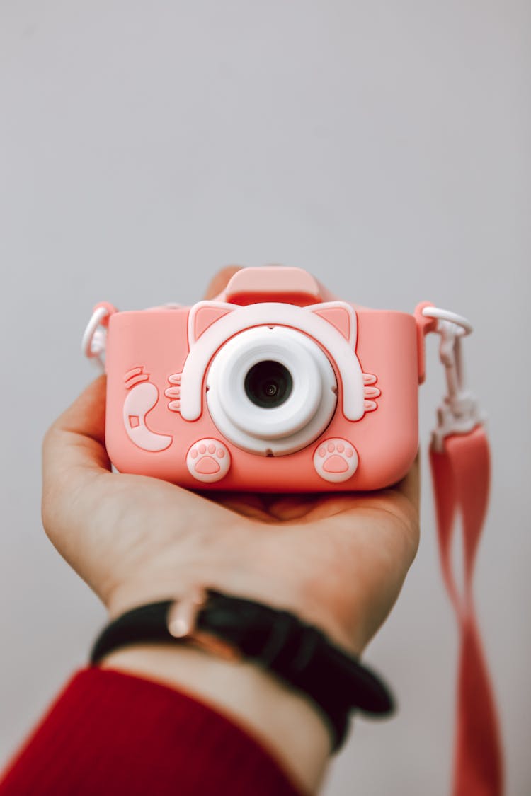 Close-up Of Person Holding A Small Digital Camera On Hand