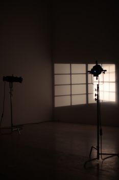 Minimalist studio scene with lights casting shadows on wall grid.