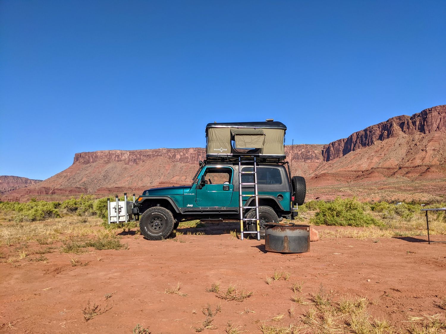 Hardshell pop-up rooftop tent mounted on a Jeep Wrangler in red rock desert overlanding camp