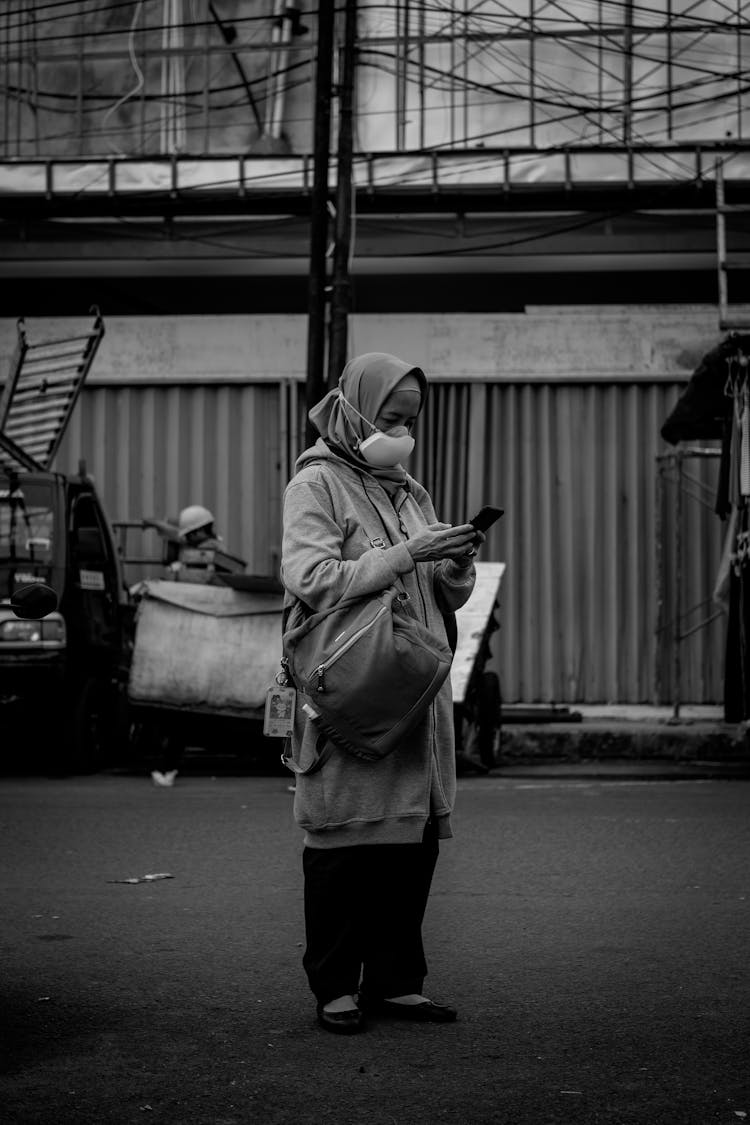 Woman In Face Mask Using Smartphone