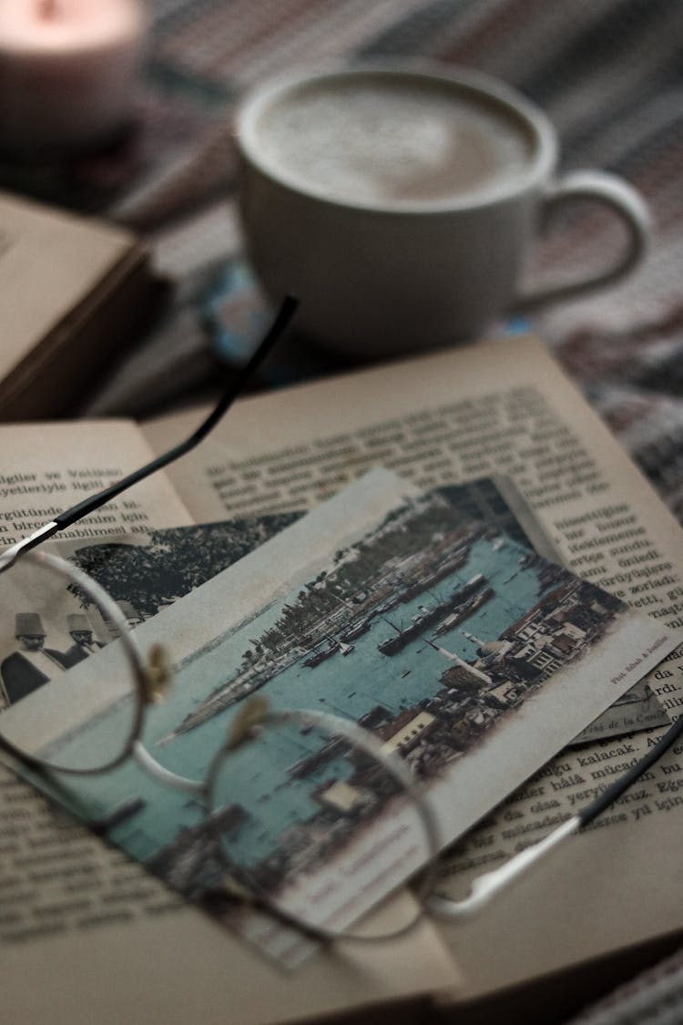 Eyeglasses On Old Book And Postcards