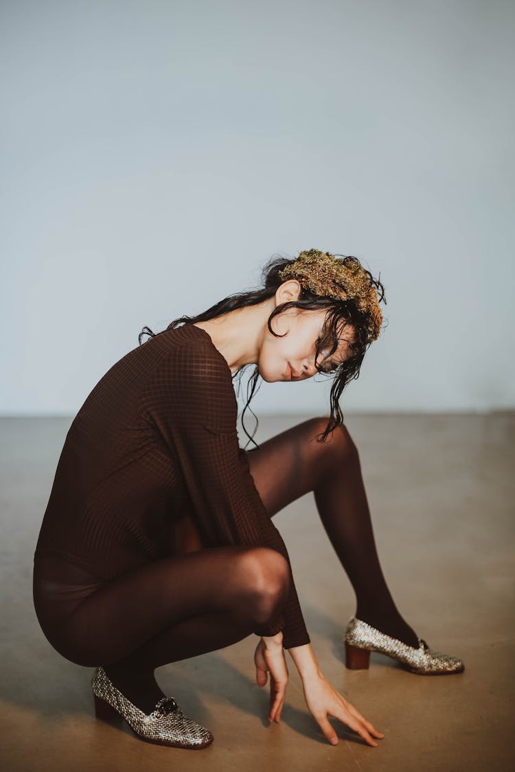 A Woman In Black Long Sleeves And Black Tights