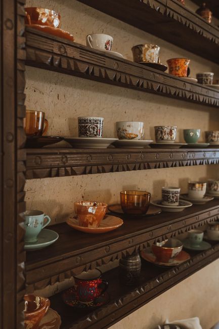 Artistic display of vintage teacups on wooden shelves in a cozy interior setting in Türkiye.
