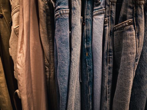 Free Close-up of various denim jeans hanging on a rack, showcasing different shades and styles. Stock Photo