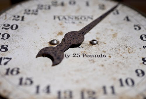 Free Close-up of an antique rusty weighing scale showing its weathered dial and numbers. Stock Photo