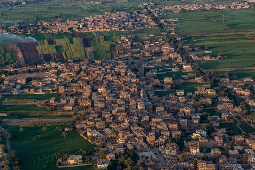 Aerial shot of a rural town with surrounding fields, showcasing urban landscape and agriculture.