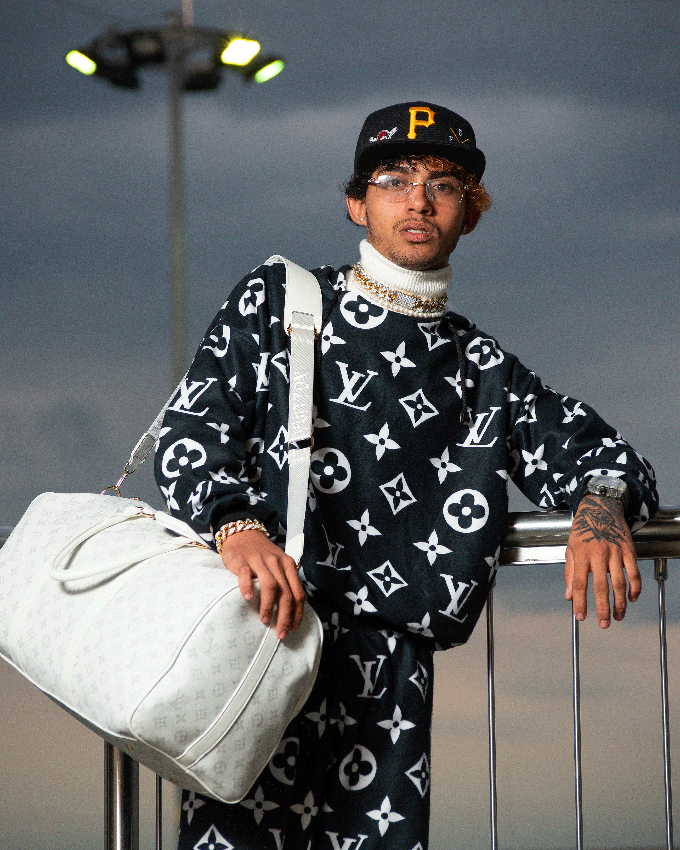 Stylish young man in luxury Louis Vuitton outfit in Cali. Perfect for fashion and travel themes.