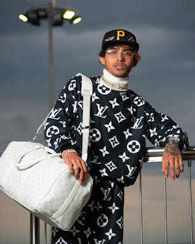 Stylish young man in luxury Louis Vuitton outfit in Cali. Perfect for fashion and travel themes.