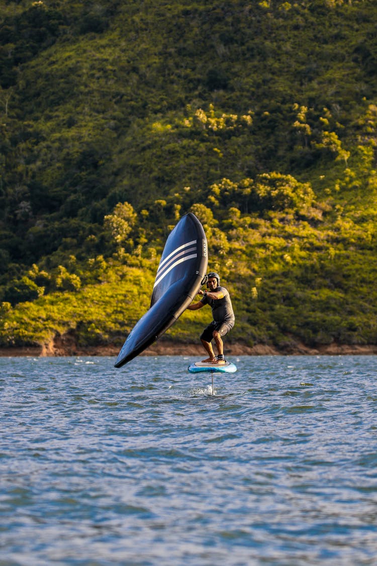 Man Sailing On Paddle With Sail