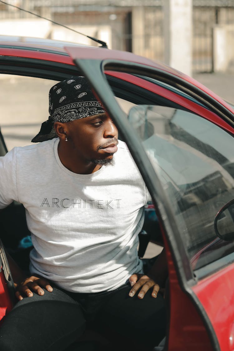 A Man In A Bandana Getting Out Of The Car