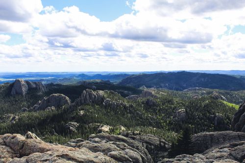Free Breathtaking view of a mountain range with lush forests under a vibrant sky. Stock Photo