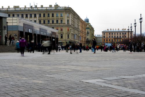 Free A dynamic urban scene with pedestrians in a historic city square. Ideal for travel and architecture themes. Stock Photo