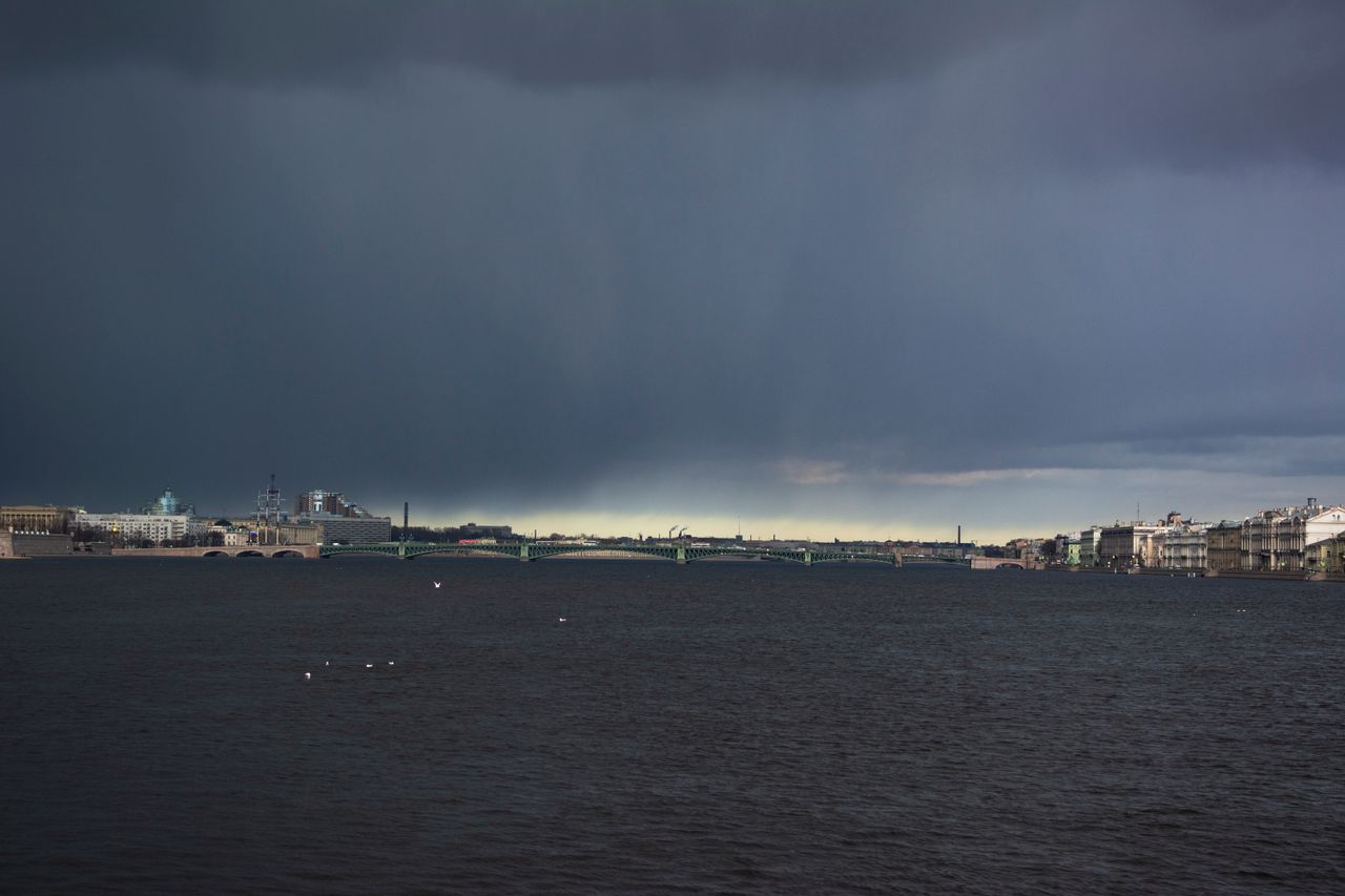 stormy sea with dark clouds over an urban skyline capturing a dramatic