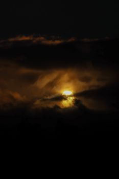A captivating view of the sunrise breaking through dark, dramatic clouds, creating a striking sky scene.