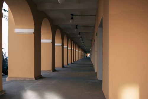 Free A vanishing perspective of arched colonnades in an urban setting, emphasizing symmetry and architecture. Stock Photo