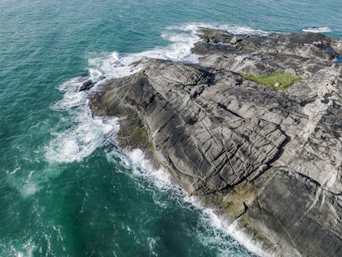 Aerial Shot of Waves Crashing  the Coastal Rocks 