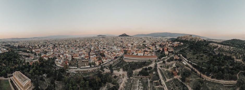 A stunning aerial view of Athens cityscape at sunrise, showcasing historical landmarks.