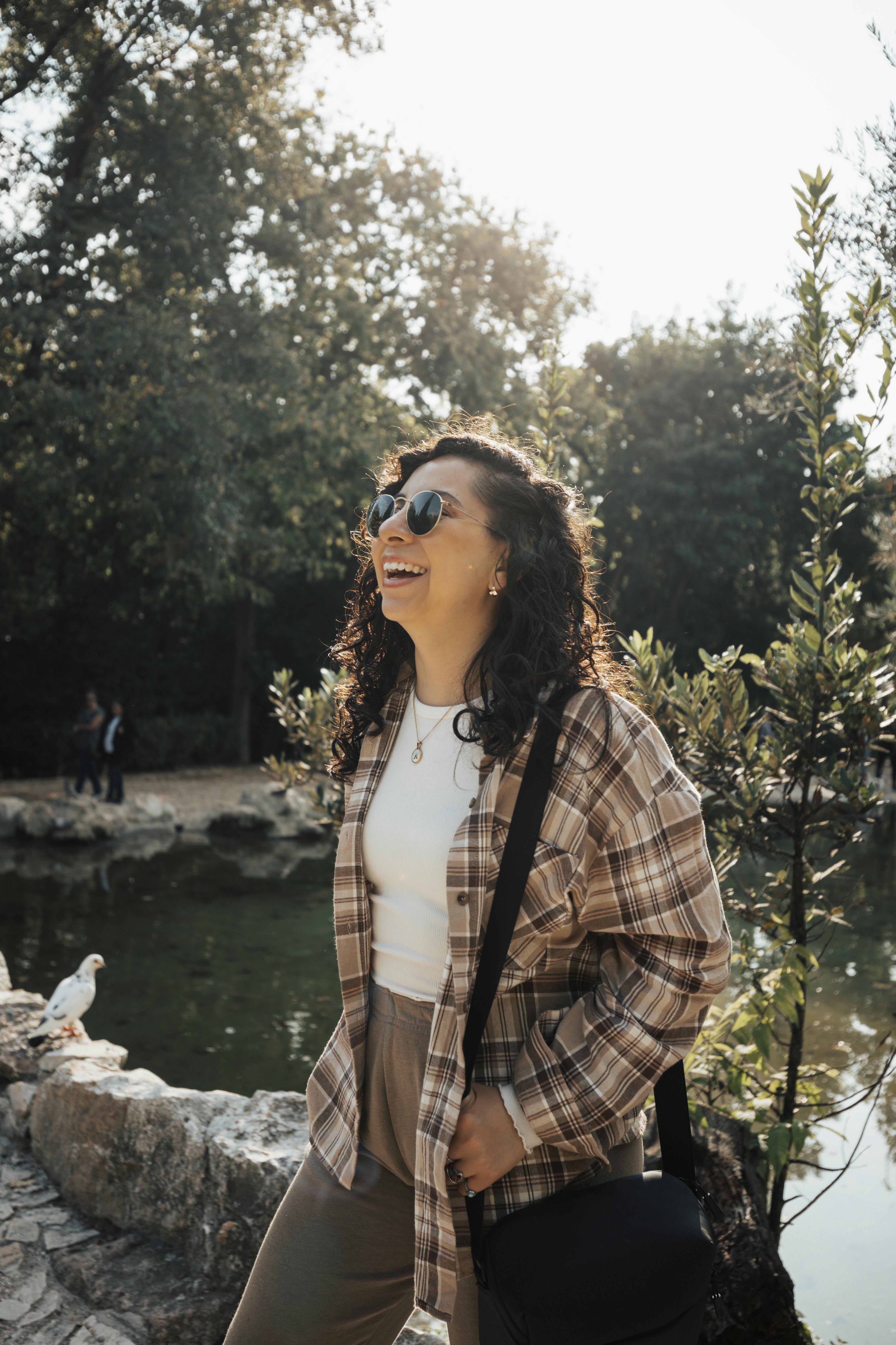 a woman in plaid shirt and sunglasses smiling