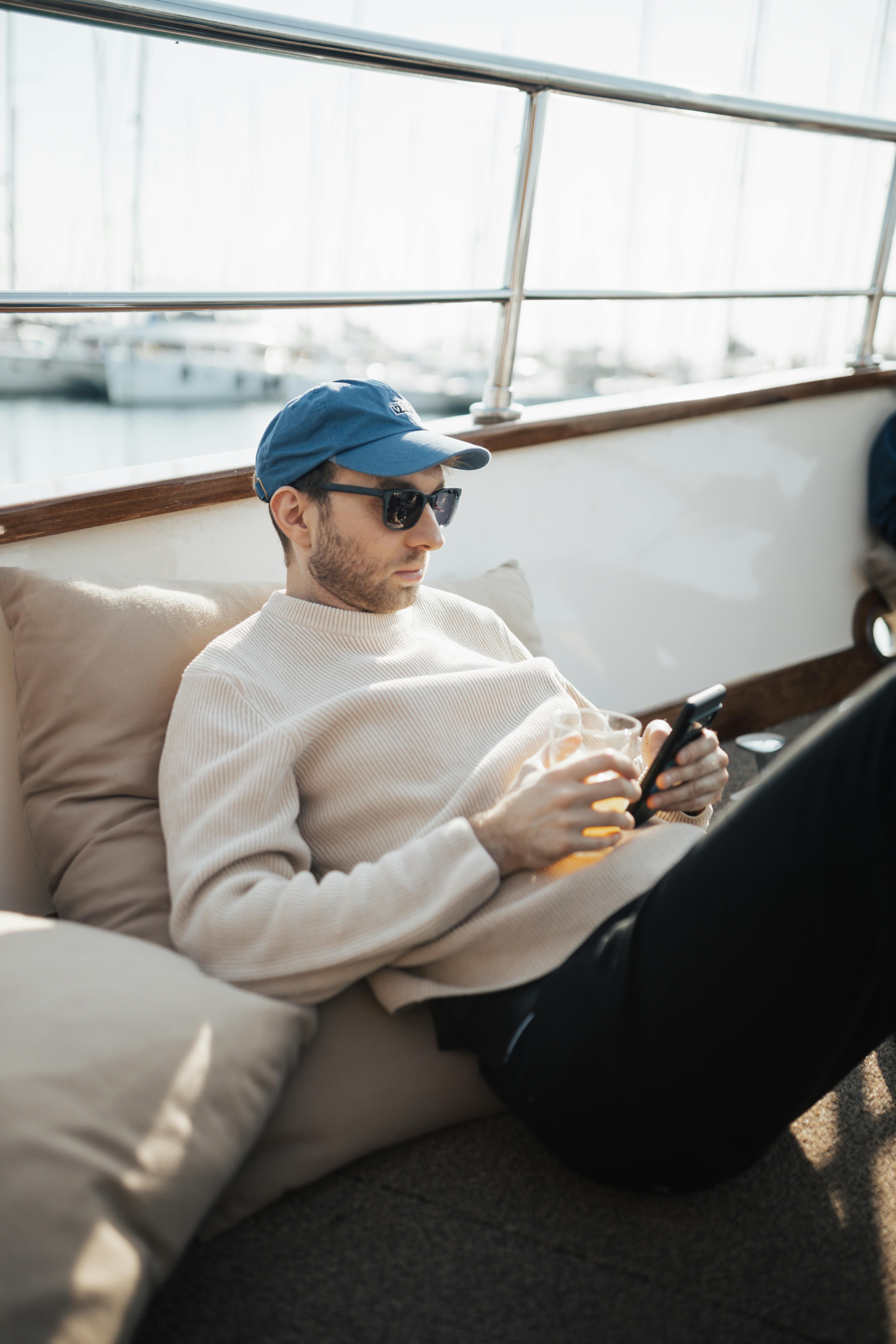 man sitting on a boat with a hat and sunglasses