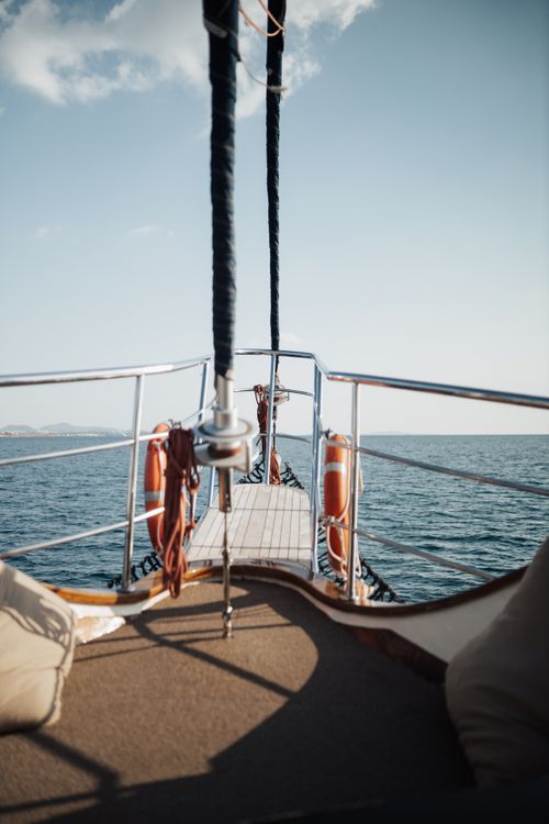 Free View from a boat deck sailing on the clear sea under a blue sky. Perfect for travel and adventure themes. Stock Photo