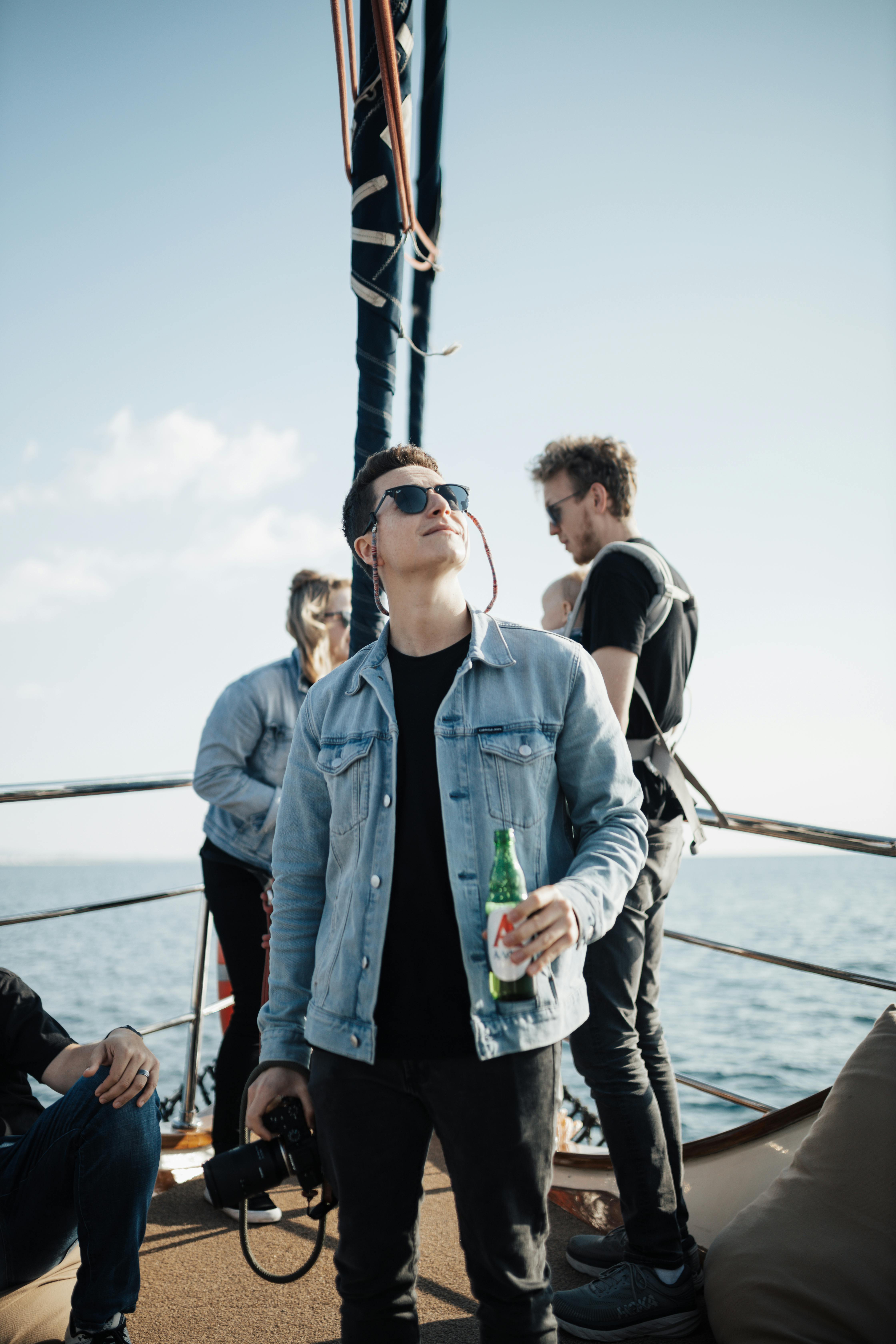 a man is standing on a boat with a beer