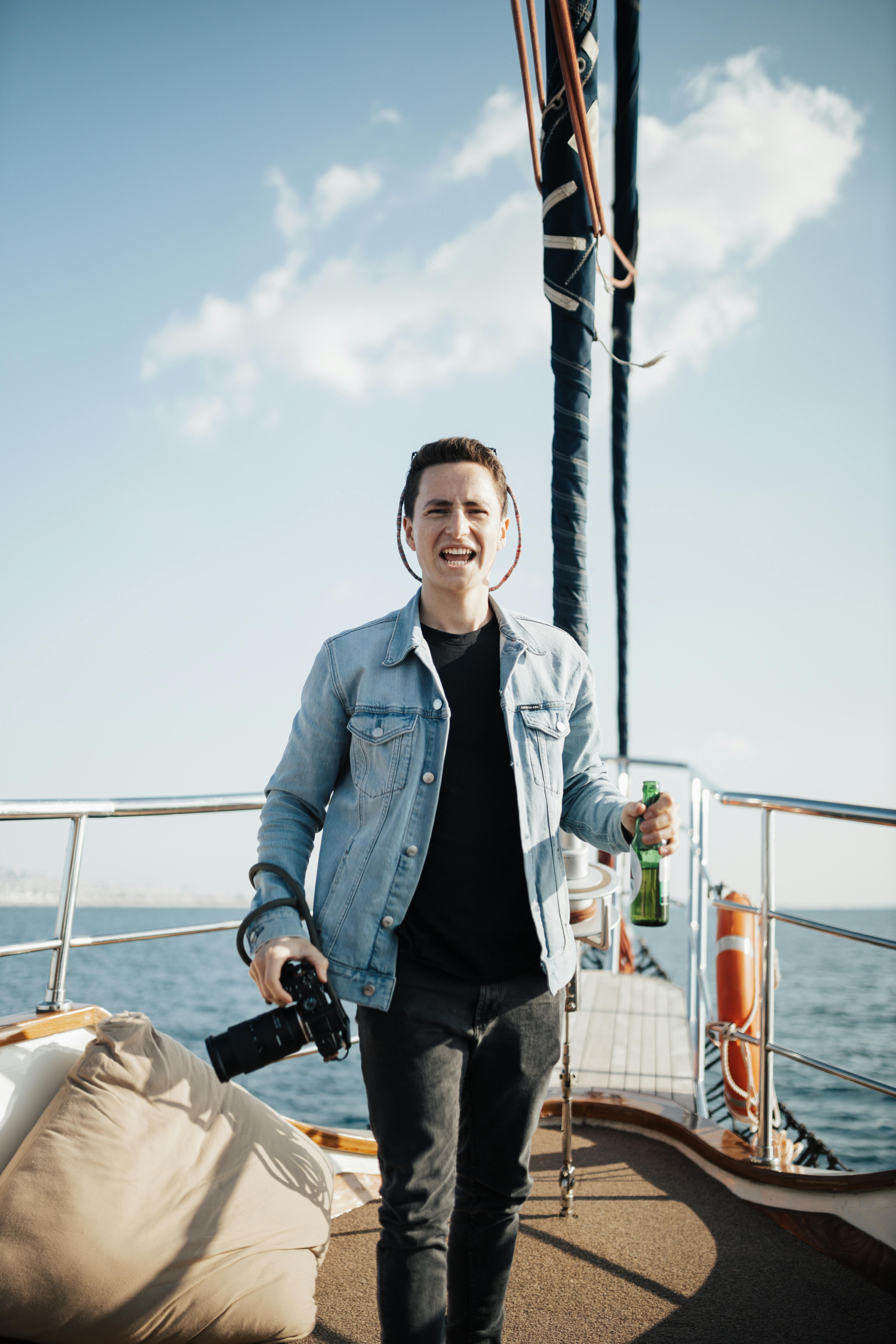 a man is standing on a boat with a beer