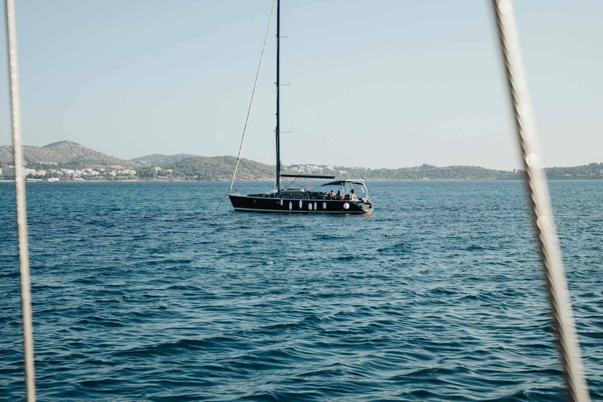 A luxury yacht sailing on calm blue sea under a clear sky, perfect for travel enthusiasts.
