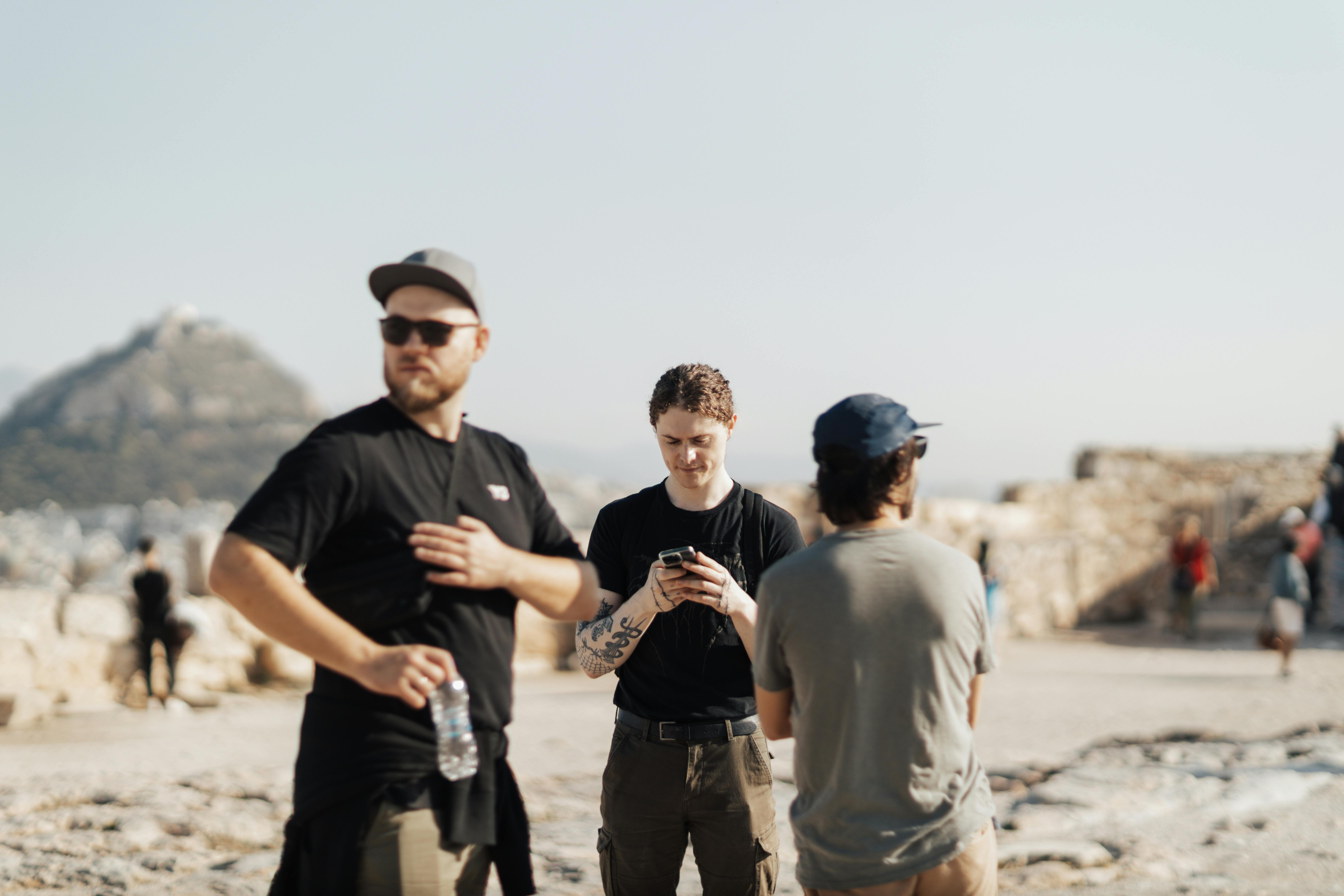 Group of tourists exploring ancient ruins with scenic mountain backdrop.