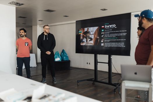 Business team giving a presentation in a modern office environment with a digital display.
