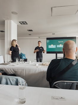 Business professionals engaged in a presentation meeting in a bright, modern office space.