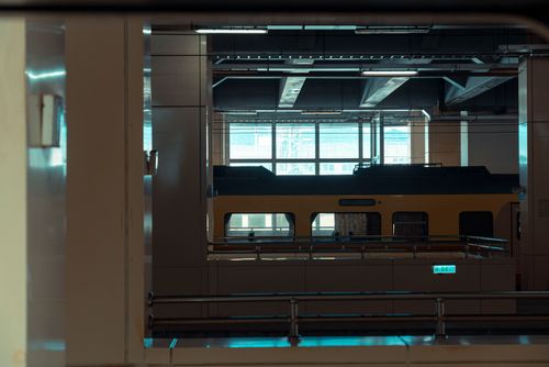 Free View of a train inside a modern station with metal railings and tiled walls. Stock Photo